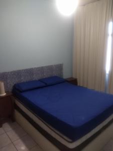 1 dormitorio con 1 cama azul en una habitación en APARTAMENTO A 300 METROS DA PRAIA DO FORTE, en Cabo Frío