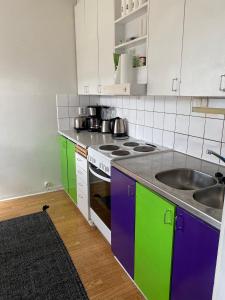 uma cozinha com armários coloridos e um lavatório em Kiva majoitus 1-4hlö, 500m keskustaan, parkkipaikka em Oulu