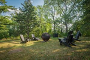 - un groupe de chaises et un grand bol dans l'herbe dans l'établissement Domaine Dorchamps, à Lac-Brome