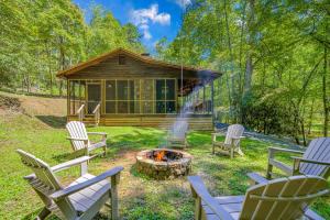 a group of chairs around a fire pit in front of a cabin at Moss Creek Cabin in Morganton