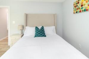 ヒューストンにあるPEERLESS RETREAT - Minutes from Downtown Houstonの白いベッドと青い枕のある寝室
