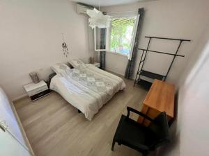 sypialnia z łóżkiem, krzesłem i oknem w obiekcie Belle et grande villa pour des séjours en famille et entre amis w mieście Cruscades