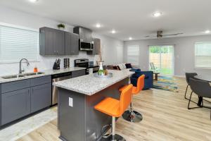eine Küche mit einer Insel mit orangefarbenen Stühlen in der Unterkunft PEERLESS RETREAT - Minutes from Downtown Houston in Houston