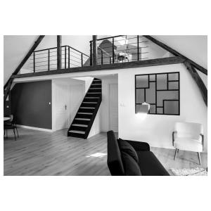 a living room with a staircase and a couch at Petit Nid Douillet in Solre-le-Château