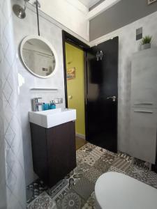ein Badezimmer mit einem Waschbecken, einem Spiegel und einem WC in der Unterkunft THE WHITE HOUSE with Pool - Playa Blanca in Playa Blanca