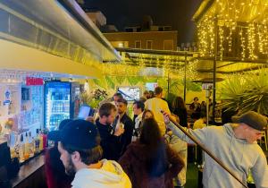 a group of people standing in a crowd in a store at Waikiki Hostel in Lima