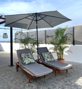 Las ToscasにあるGirasol Houseのビーチのパラソル下の椅子2脚