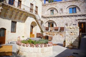 a stone building with a staircase and a courtyard at House 1938 Special Cave Hotel in Ortahisar