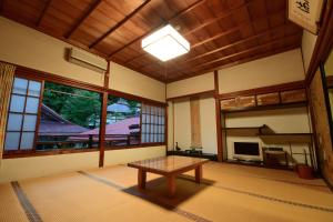 una stanza con tavolo al centro di una stanza di 高野山 宿坊 大明王院 -Koyasan Shukubo Daimyououin- a Koyasan
