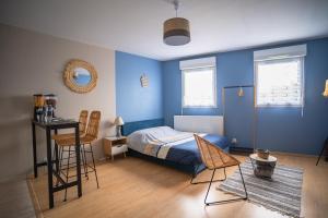 1 dormitorio con paredes azules, 1 cama y sillas en L'Effet-Mer - Tout équipé - Parking Privé - Wifi en Saint-Nazaire