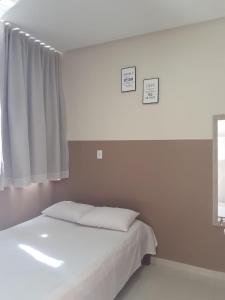 sypialnia z białym łóżkiem i oknem w obiekcie Center Prime Hotel w mieście Bom Jesus da Lapa