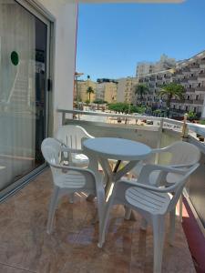 un tavolo e sedie su un balcone con vista di Playa del Ingles Cosy Apartment a Maspalomas