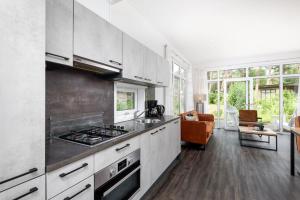 a kitchen with white cabinets and a stove top oven at Forestlodge in het Vechtdal - 5 persoons in Hardenberg