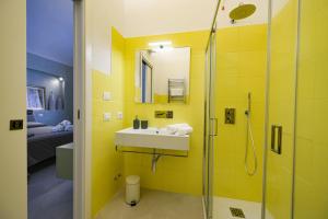 a yellow bathroom with a sink and a shower at 42° parallelo in Termoli +24 photos