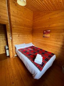 a bedroom with a bed in a wooden room at Red Squirrel Lodge in Galway