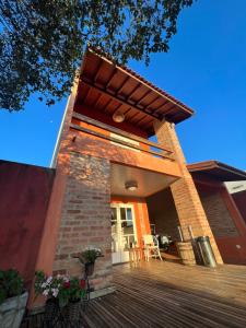 a brick house with a porch and a deck at Loft em Brotas in Brotas