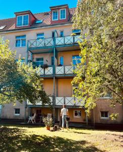 Ein Mann steht vor einem Gebäude. in der Unterkunft Ferienwohnung Rostock Nähe Warnemünde in Rostock