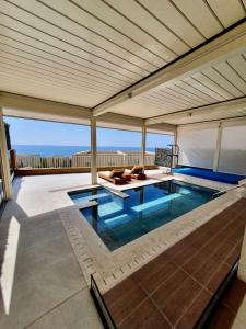 a swimming pool in a house with a roof at Green Coast Resort & Residences 94 in Palasë