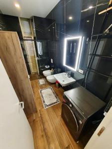 La grande salle de bains est pourvue d'un lavabo et de toilettes. dans l'établissement Green Coast Resort & Residences 94, à Palasë