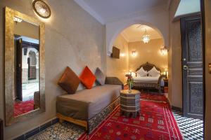 1 dormitorio con cama y espejo grande en Riad Mazaj, en Marrakech