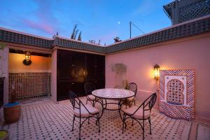 a patio with a table and chairs on a patio at Riad Mazaj in Marrakesh