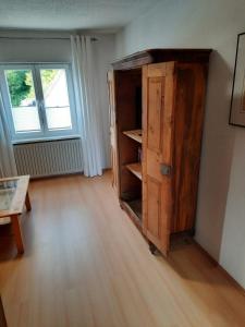 an old wooden cabinet in a room with a window at Neugärten in Busenberg