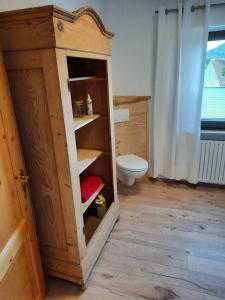 a bathroom with a toilet and a wooden cabinet at Neugärten in Busenberg