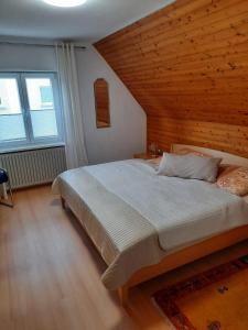 1 dormitorio con 1 cama grande y techo de madera en Neugärten, en Busenberg