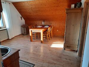 cocina con mesa de madera y sillas en una habitación en Neugärten, en Busenberg
