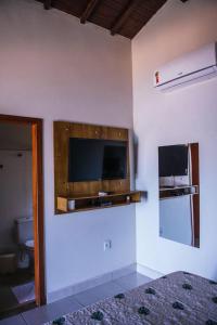 a room with a flat screen tv on a wall at Pousada Enseada da Ilha in Capitólio