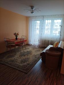 a living room with a table and chairs and a bed at Centrinio parko apartamentai in Šiauliai