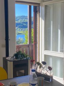 a table with a window with a view of a lake at Romantica terrazza sul lago in Revine Lago