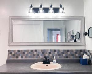 a bathroom sink with a large mirror above it at Trendy Ivy 2-bedroom Apartment Near Dt Coalinga in Coalinga +11 photos