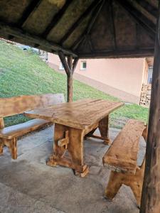 einem Picknicktisch aus Holz und einer Bank unter einem Zelt in der Unterkunft Vikendica Čeperković #2 in Kopaonik