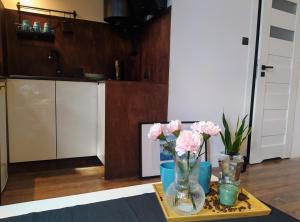 stół z wazonem z różowymi kwiatami w obiekcie Studio w Centrum Bydgoszczy w Bydgoszczy