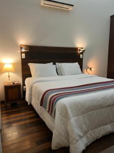 a bedroom with a large bed and a night stand at Loft em Brotas in Brotas