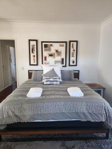 a bedroom with a large bed with two pillows at Brom Cottage in Mooloolah