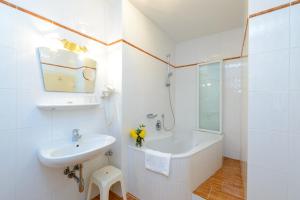 een witte badkamer met een wastafel en een bad bij Hotel-Gasthof Maria Plain in Bergheim