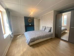 ein Schlafzimmer mit einem Bett in der Mitte eines Zimmers in der Unterkunft Maison indiv au cœur du vignoble champenois in Lignol-le-Château