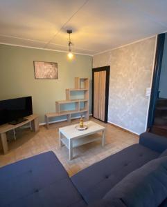 - un salon avec un canapé bleu et une table dans l'établissement Maison indiv au cœur du vignoble champenois, à Lignol-le-Château