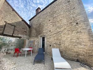 un mur en briques avec deux chaises et une table dans l'établissement Maison indiv au cœur du vignoble champenois, à Lignol-le-Château