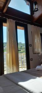 ein Schlafzimmer mit einem Bett und einem großen Fenster in der Unterkunft Hotel The First in Gjirokastër