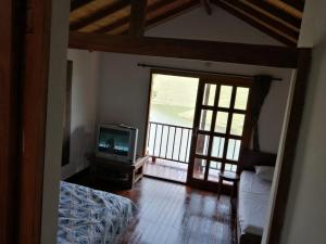 een slaapkamer met een bed, een tv en een raam bij Finca 1 - Dakeva in Guatapé