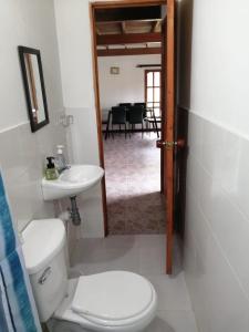 een badkamer met een toilet, een wastafel en een tafel bij Finca 1 - Dakeva in Guatapé