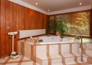 uma banheira num quarto com paredes de madeira em Hotel Boutique Almahue em Pichidegua