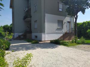 a large white building with stairs and a tree at Casa Vacanze I Giardini di Marzo in San Giorgio Di Mantova