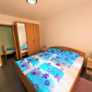 a bedroom with a bed with a blue comforter at Holiday house with a big garden and free parking 