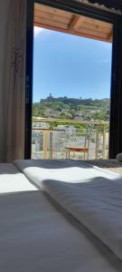 1 dormitorio con 1 cama y balcón con vistas. en Hotel The First, en Gjirokastra