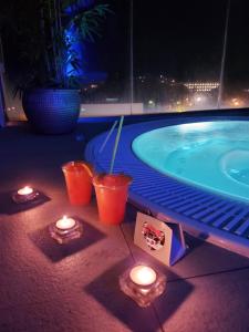 a pool with candles and lights next to a swimming pool at Hotel Spa Pinar del Mar in Platja  d'Aro