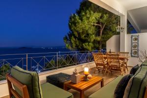 a balcony with a view of the ocean at night at The Sea House Skiathos in Skiathos